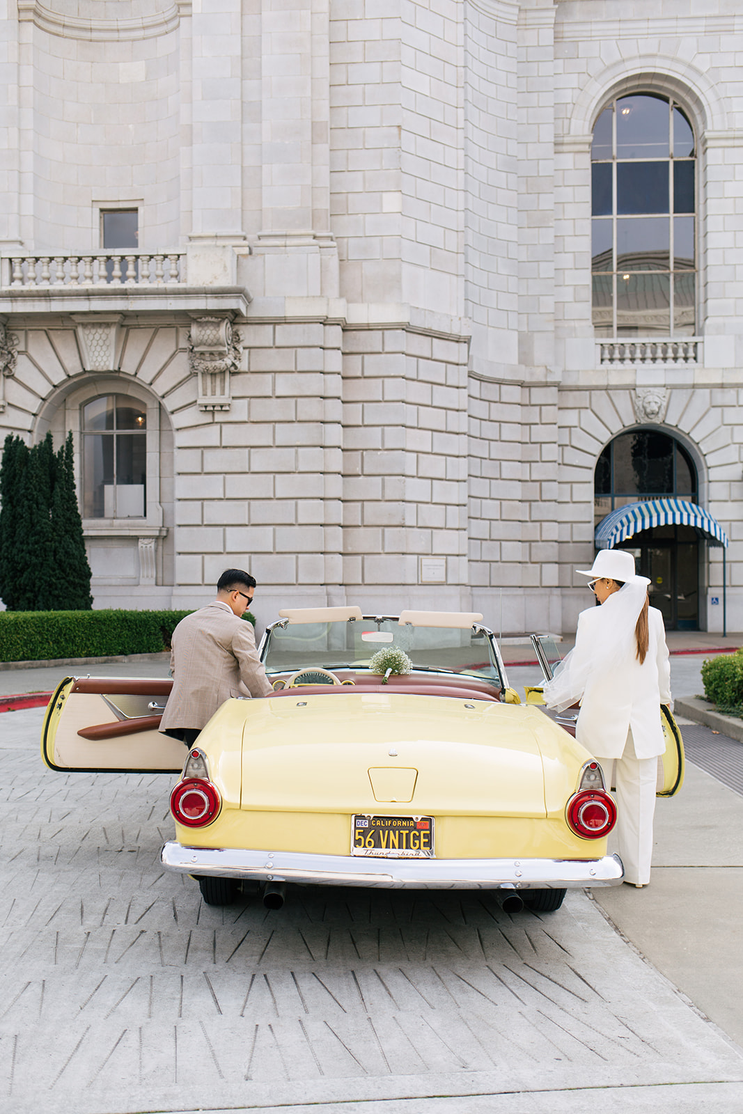 a couple getting inside of a yellow classic car