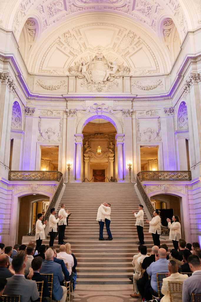 A couple during their first kiss at their wedding at city hall 