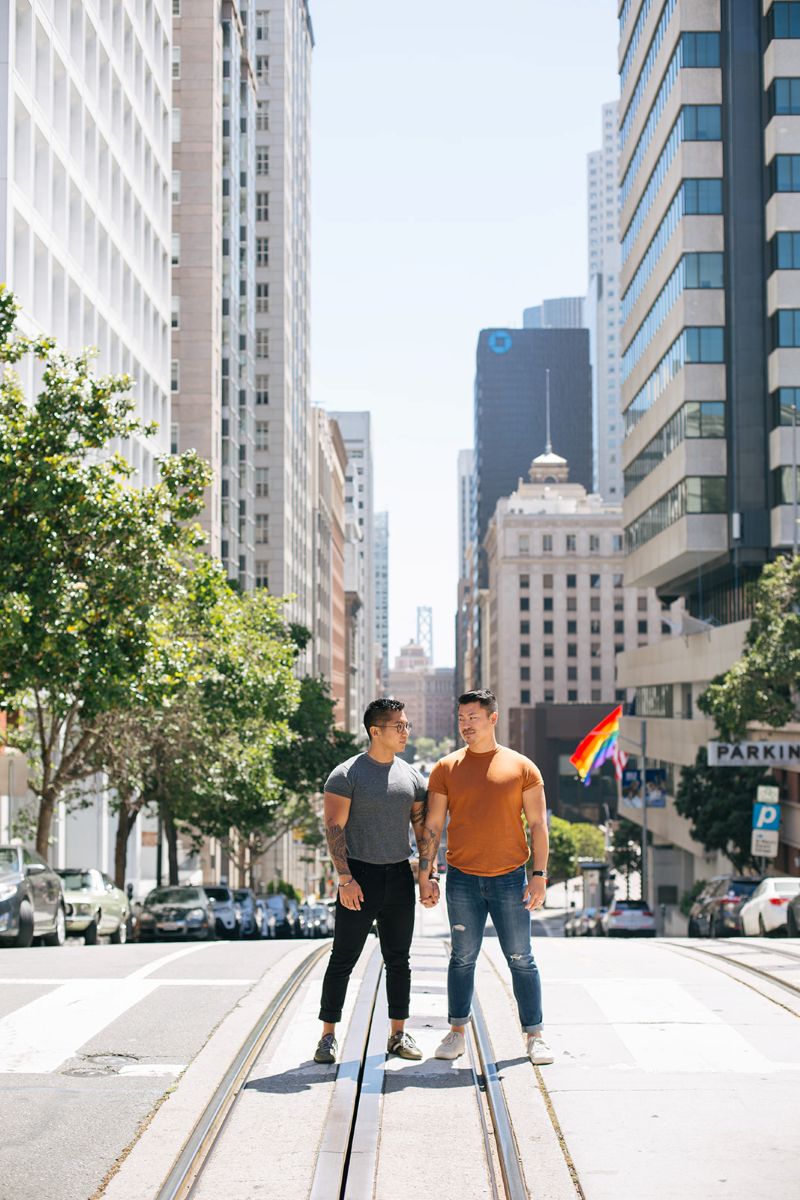 a couple holding hands together and taking engagement photos in downtown san francisco