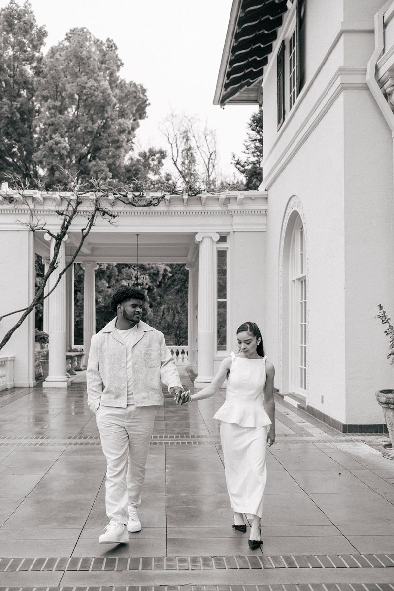 a couple walking hand in hand on the pavilion taking enagement photos at villa montalvo