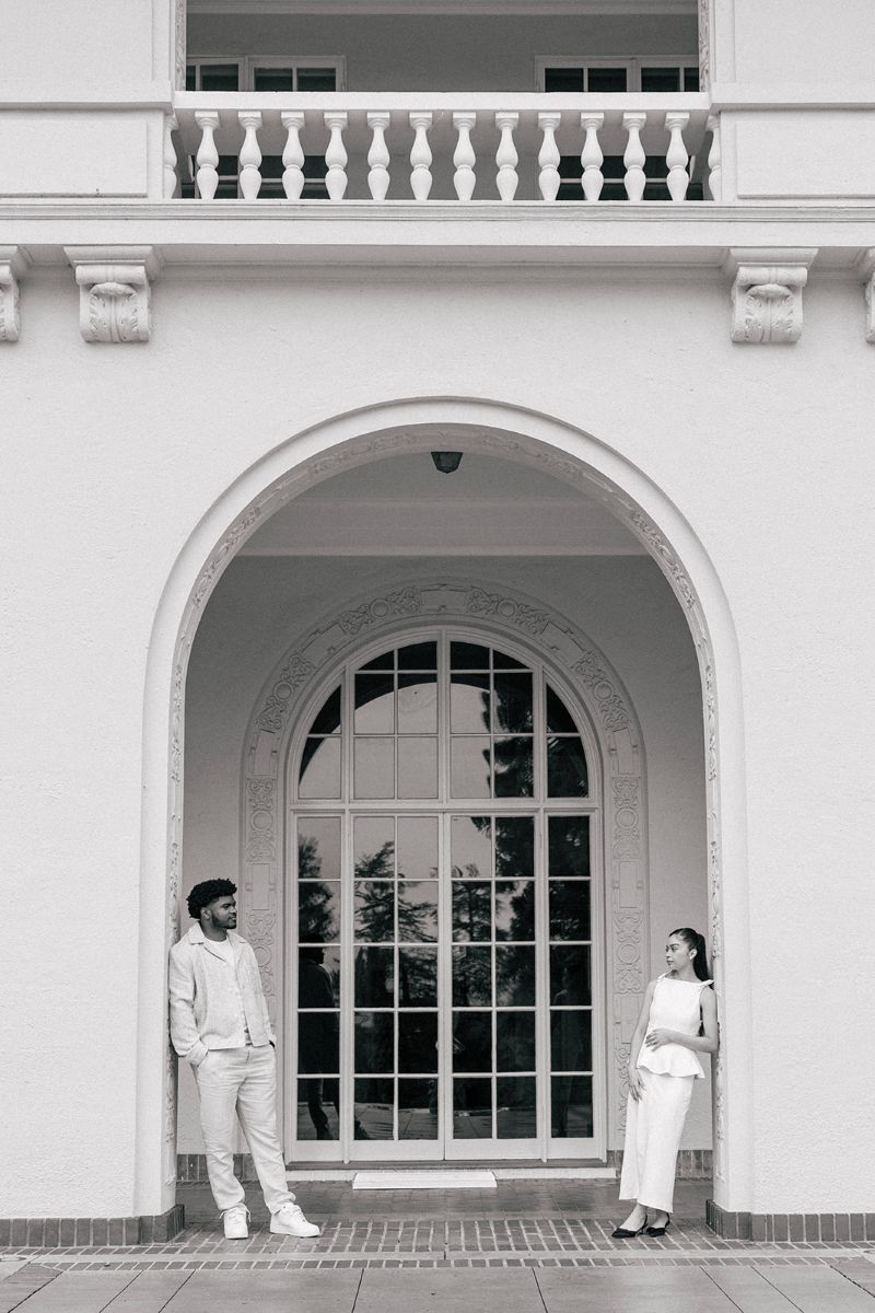 a couple standing in an archway at villa montalvo they are both on opposite sides and looking at one another