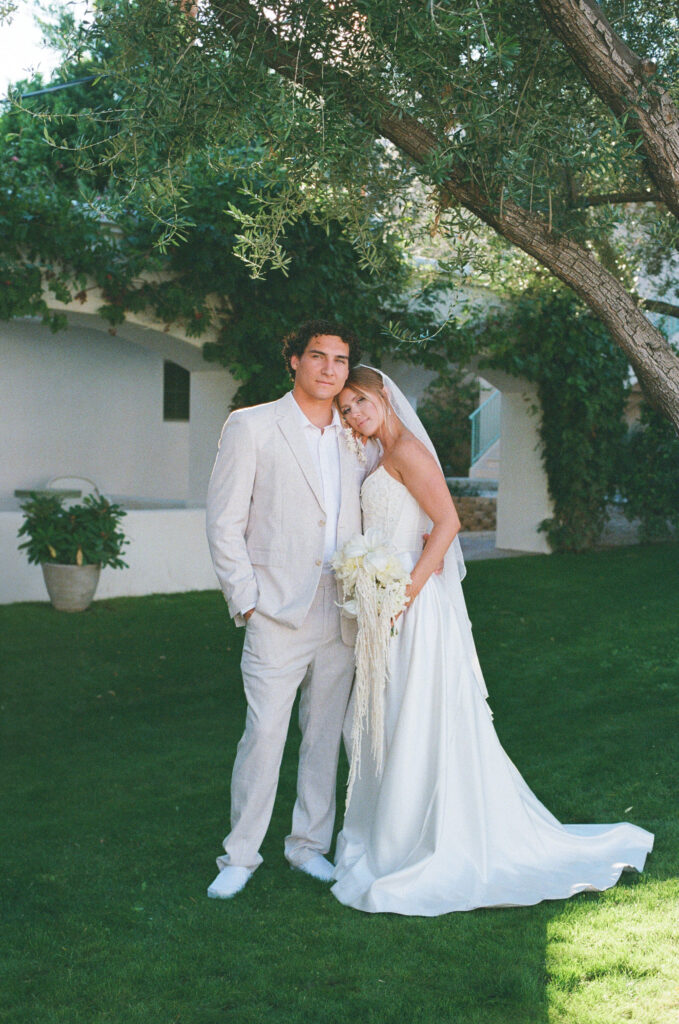 a wedding couple posed under a tree taken on 35mm film