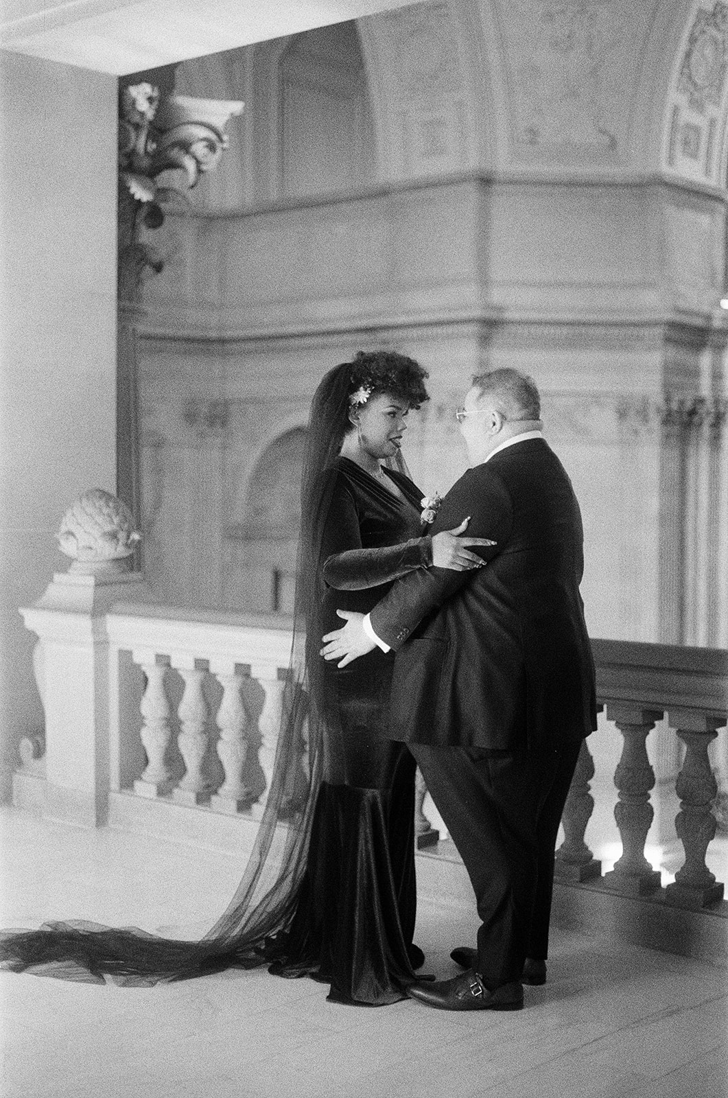 a couple embracing each other in san francisco city hall on the day of their wedding 