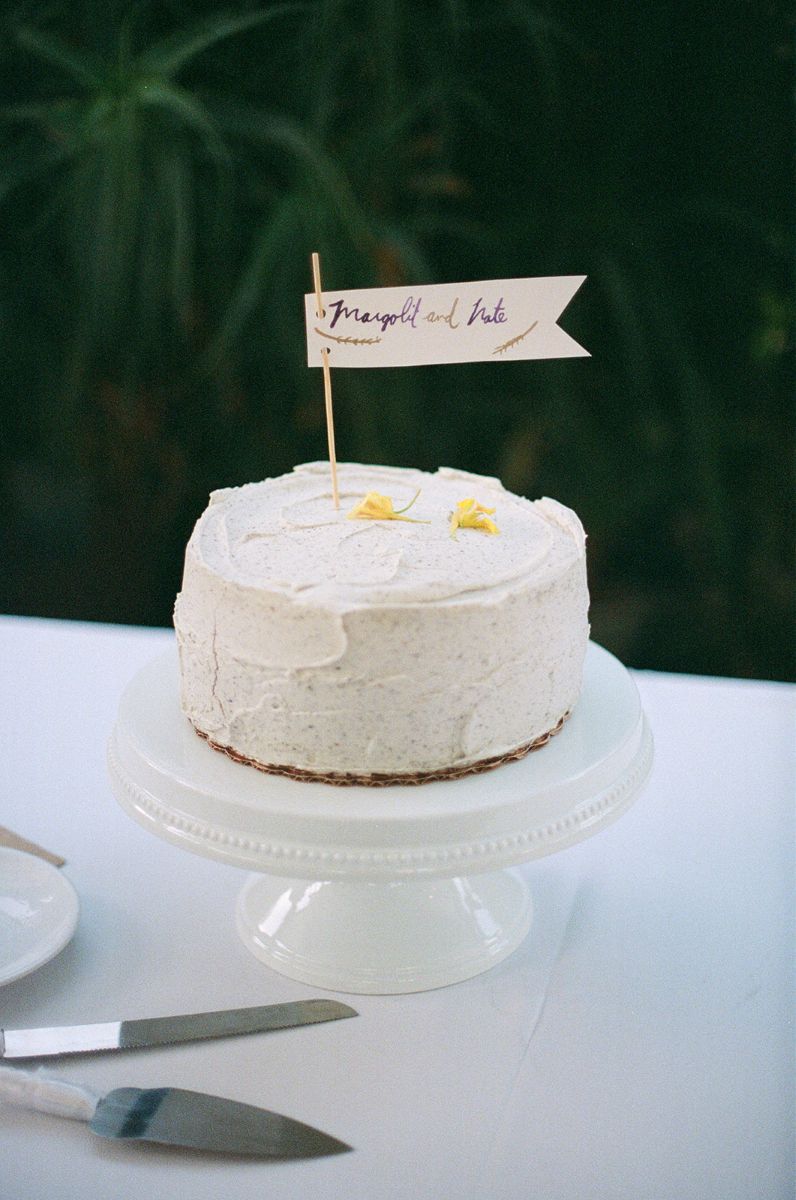 a wedding cake on a white serving tray on  a table captured on film 