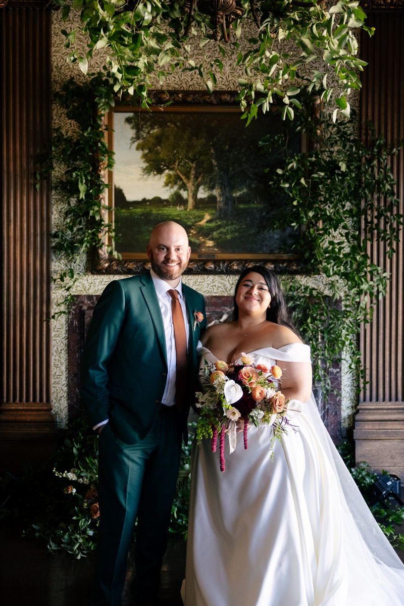 a couple posing in front of the fireplace at the University Club of San Francisco after their wedding ceremony 