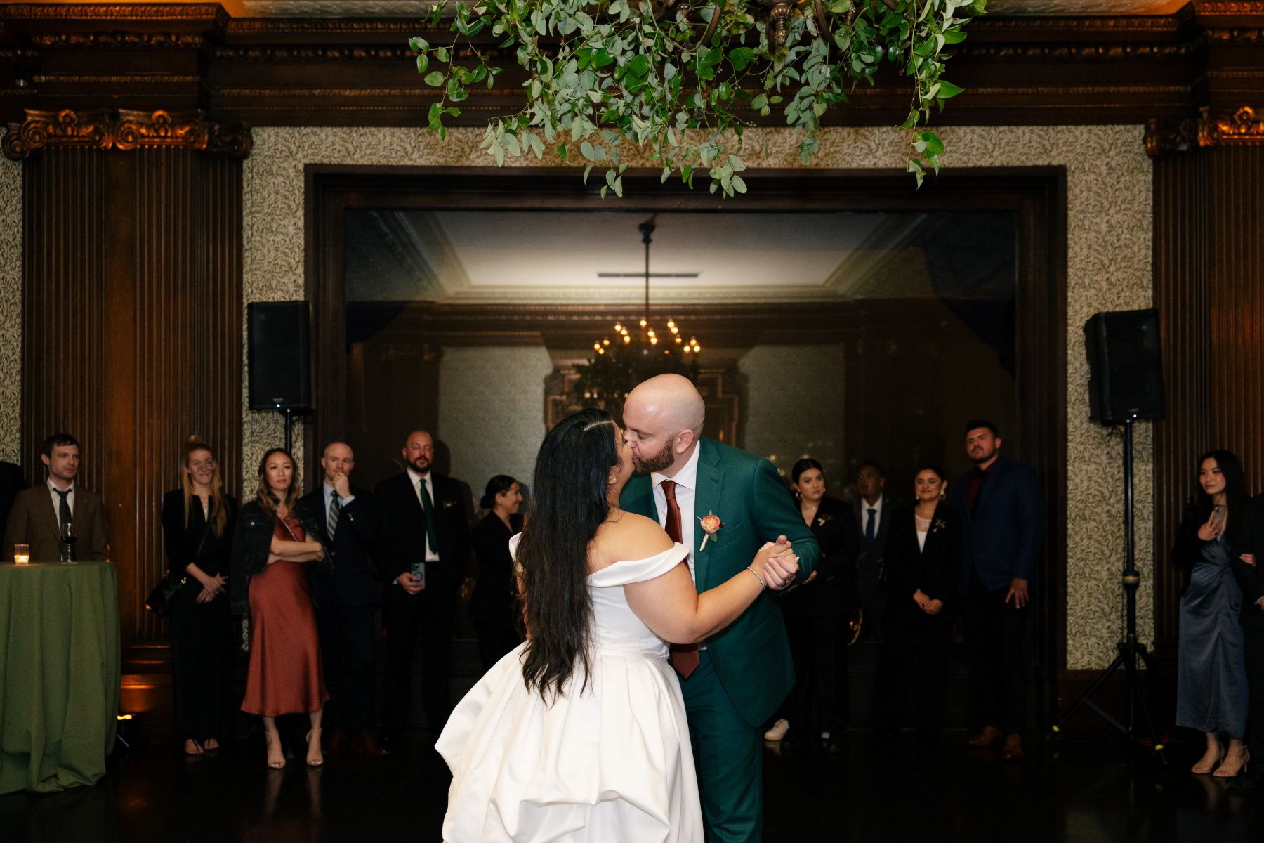 a couple sharing a first dance and kissing at their wedding reception in the University Club of San Francisco