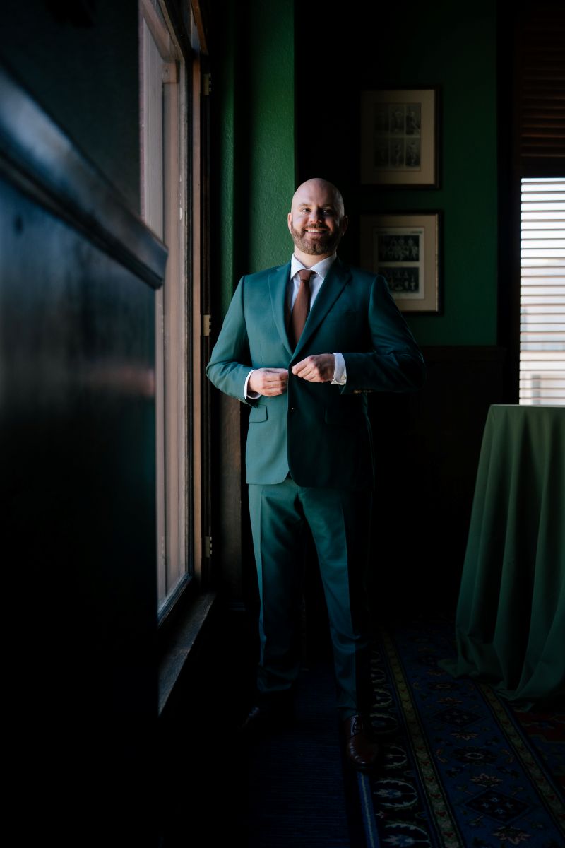 a man buttoning his tuxedo for his wedding 