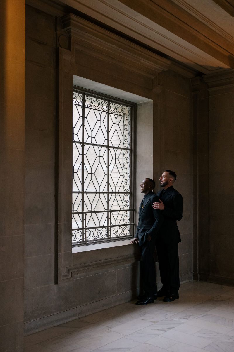 a couple on the 4th floor of san francisco city both looking out a window