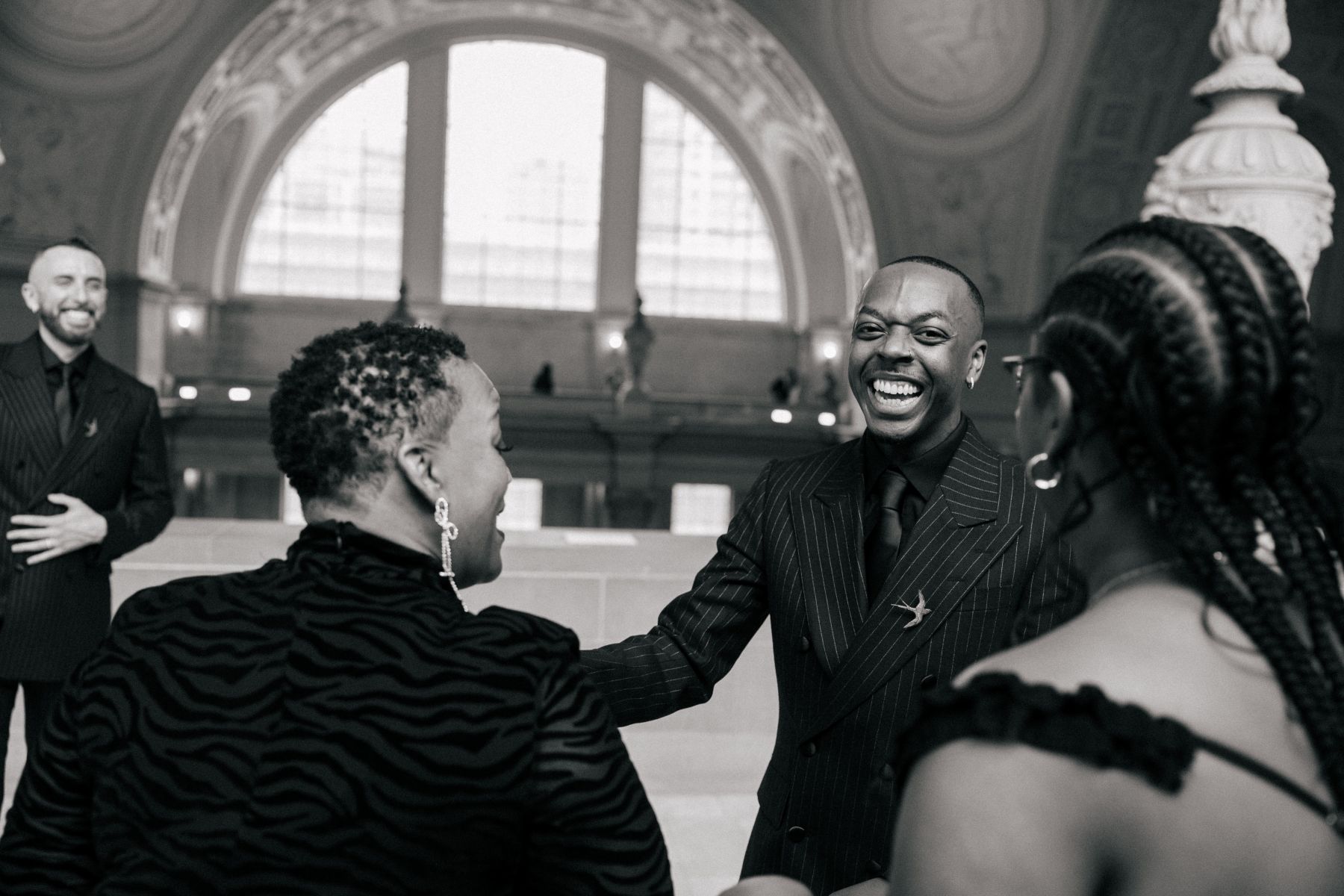 a couple laughing after their wedding ceremony in san francisco city hall with their guests