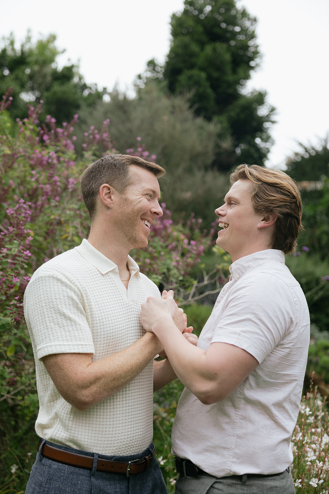 a couple holding hands and laughing at san francisco botanical gardens