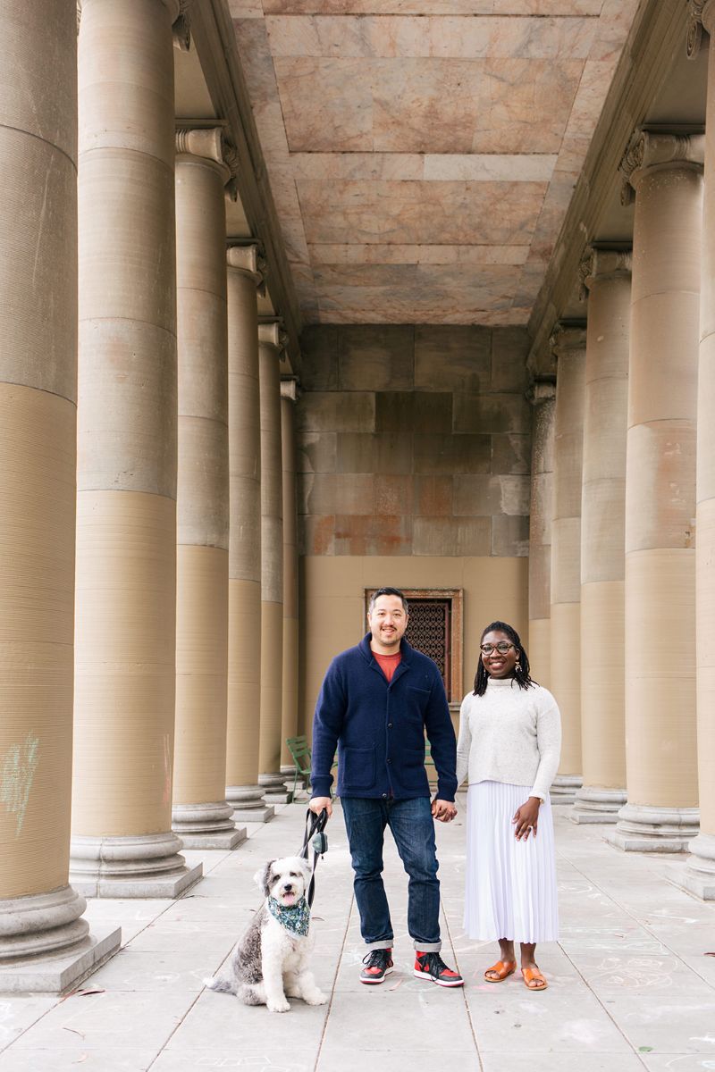a couple taking engagement photos with their dog at the music concourse in golden gate park 