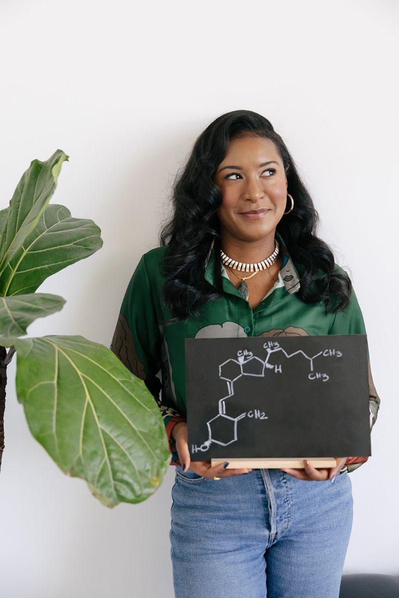 the owner of ebb and flow nutrition and consulting holding upa diagram and standing next to a plant
