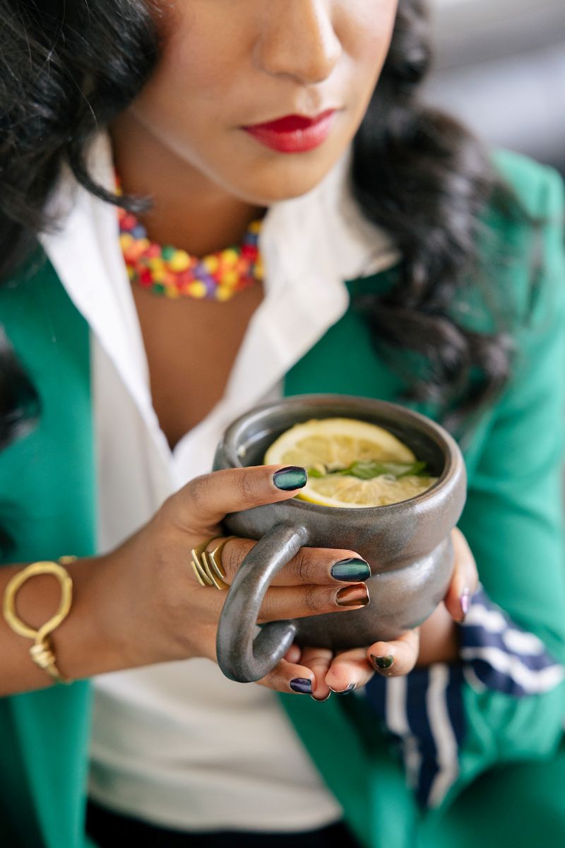 the owner of ebb and flow nutrition and consulting holding a mug with a lemon in it for a portrait during her personal branding session