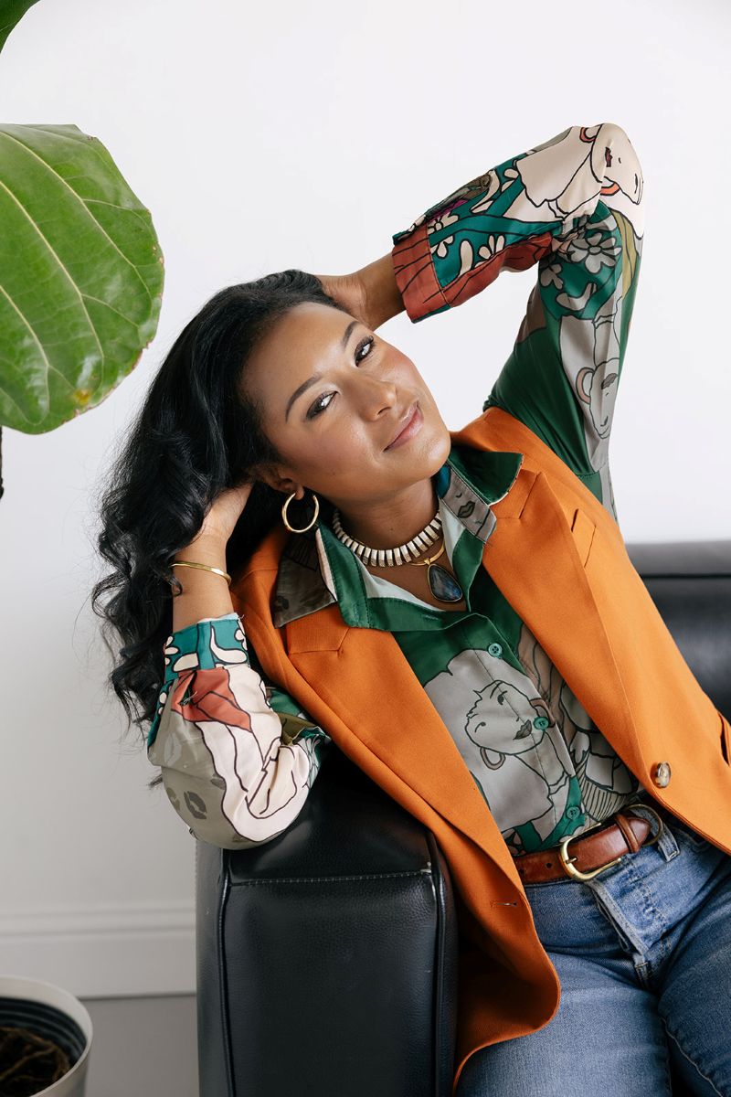 the owner of ebb and flow nutrition and consulting sitting on a black leather couch for her personal branding session