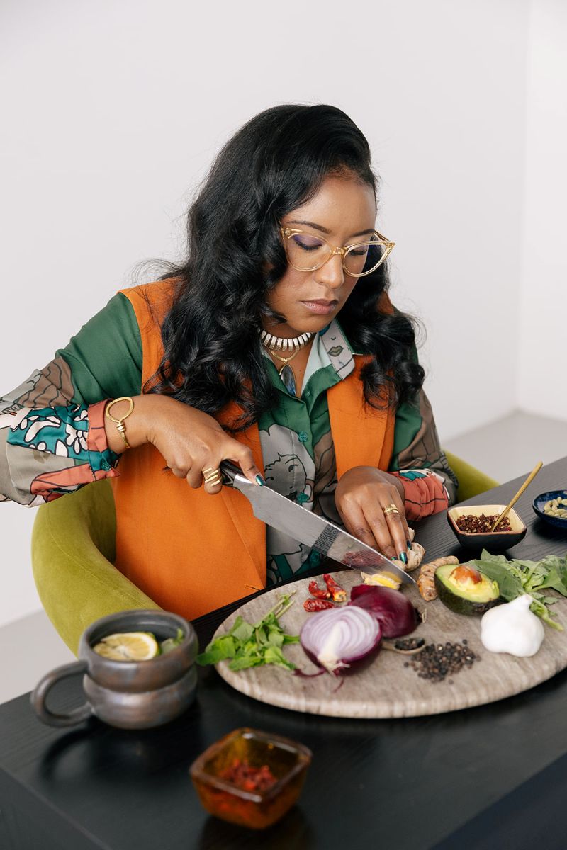 the owner of ebb and flow nutrition and consulting cutting vegetables at a table during her personal branding photography session