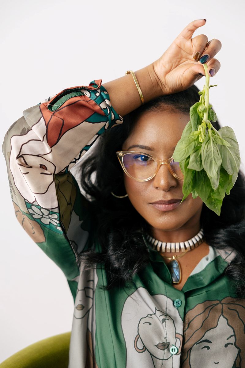 the owner of ebb and flow nutrition and consulting holding up a lettuce leaf in front of her eye