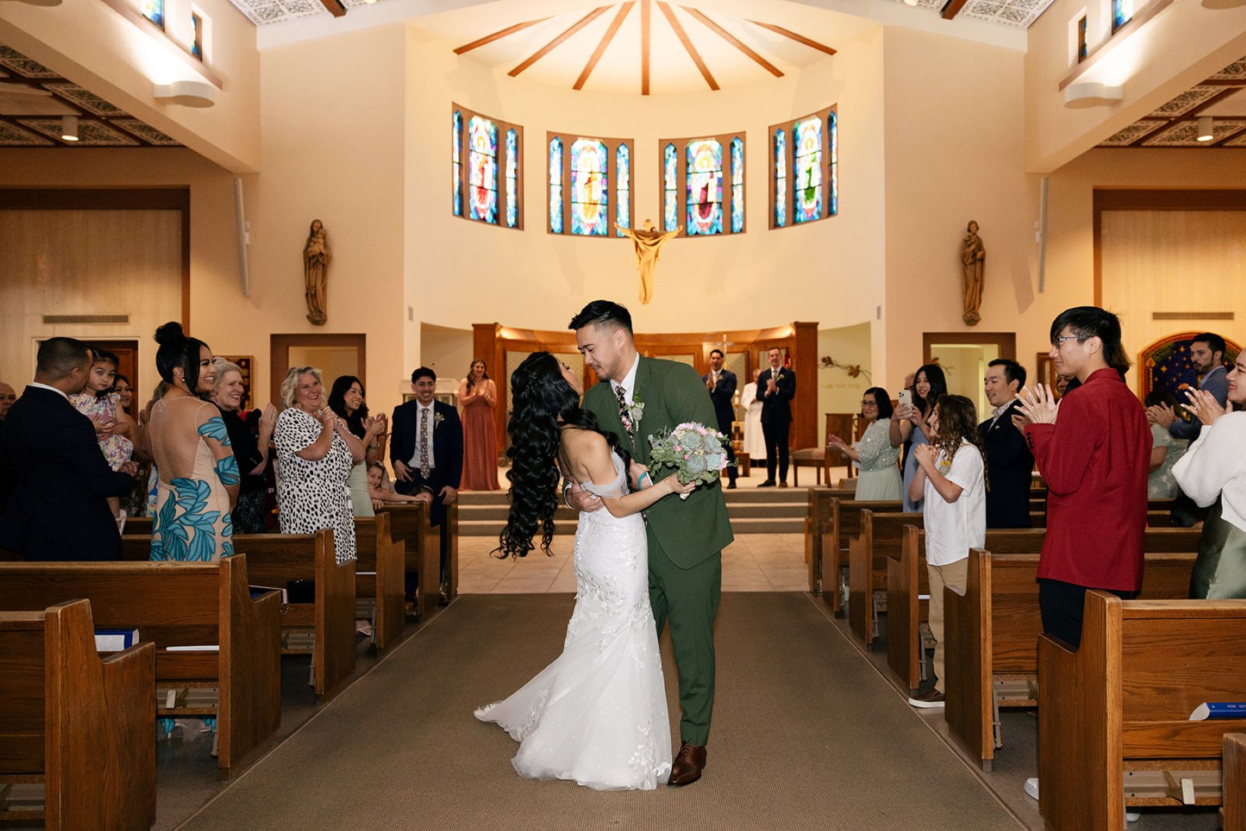 a couple in the aisle of Apollinaris Catholic Church after their wedding ceremony 