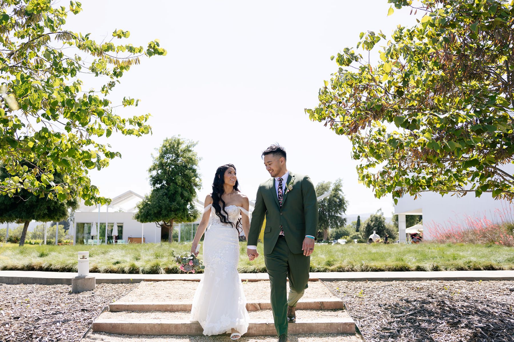 a couple walking hand in hand down the steps in front of ashes and diamonds winery in napa valley 