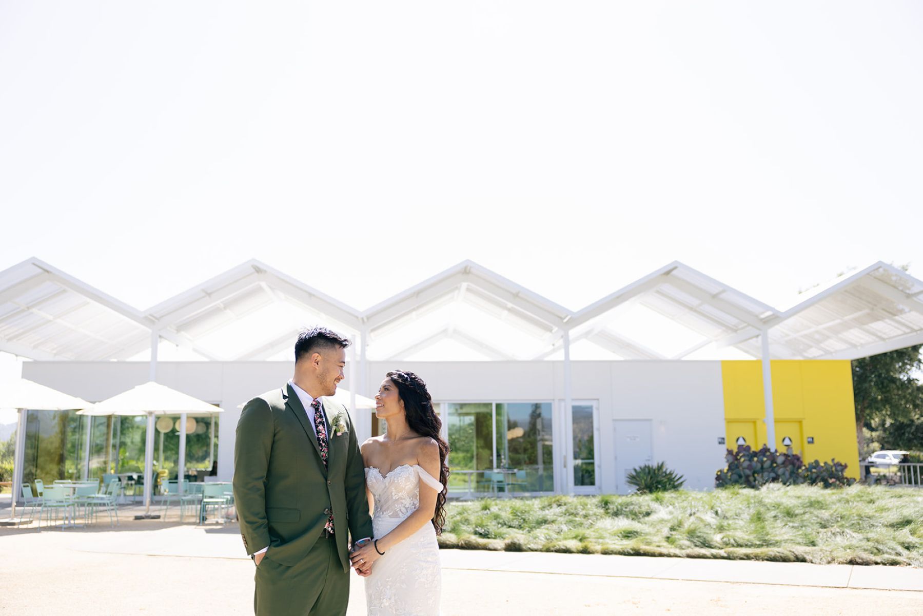a couple taking wedding portraits in front of ashes and diamonds winery
