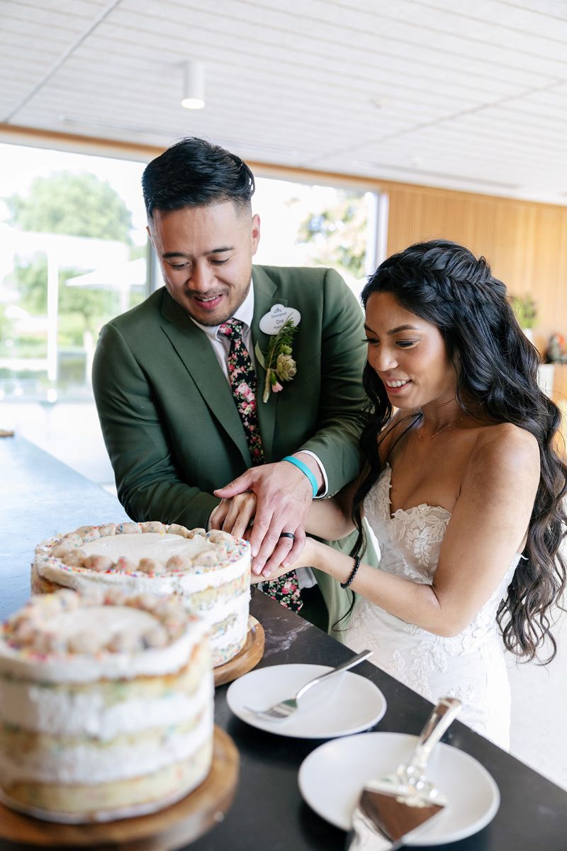 a couple cutting their wedding cake inside of ashes and diamond winery during their wedding reception 
