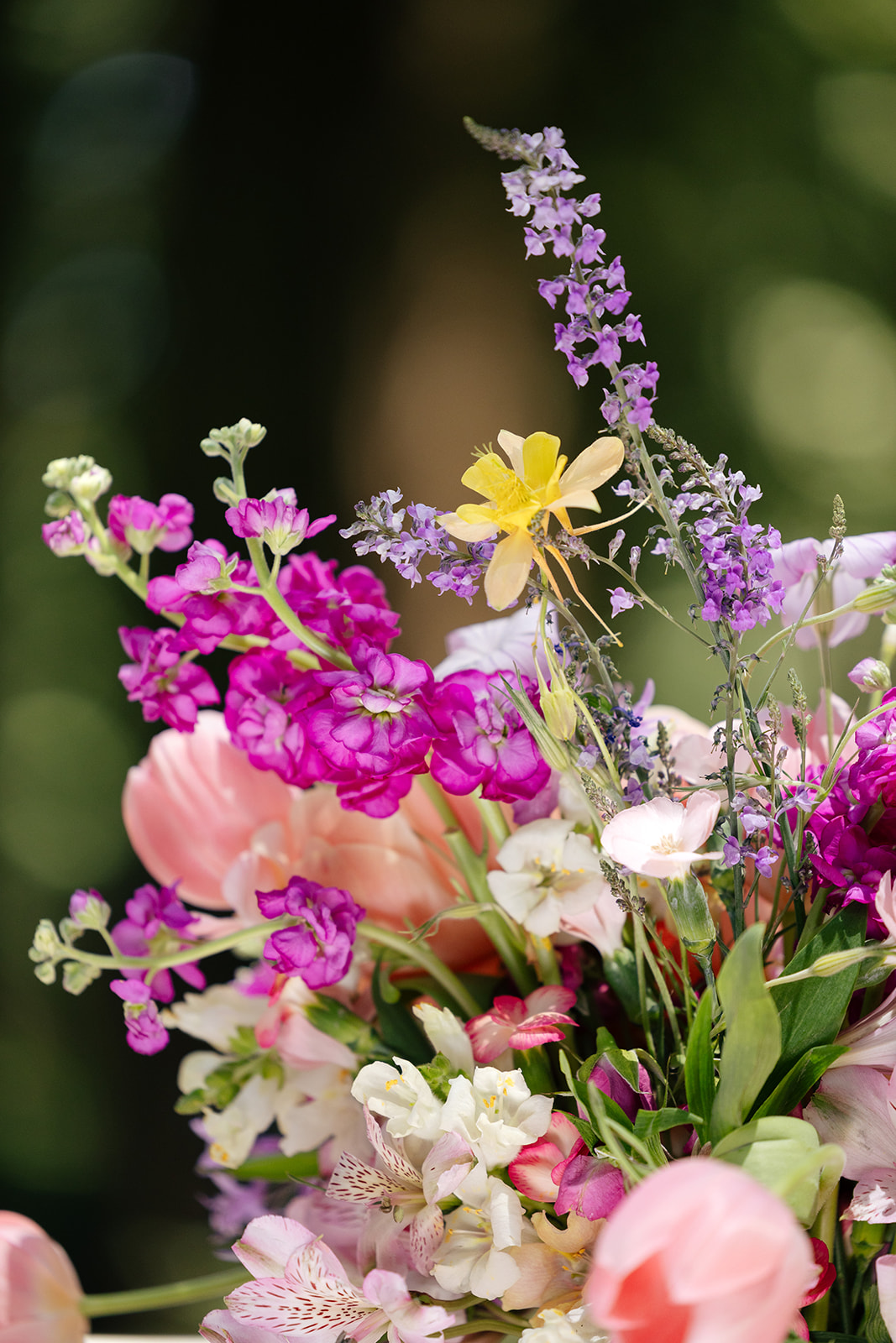 a colorful floral arrangement consisting of pink, purple, and yellow flowers 