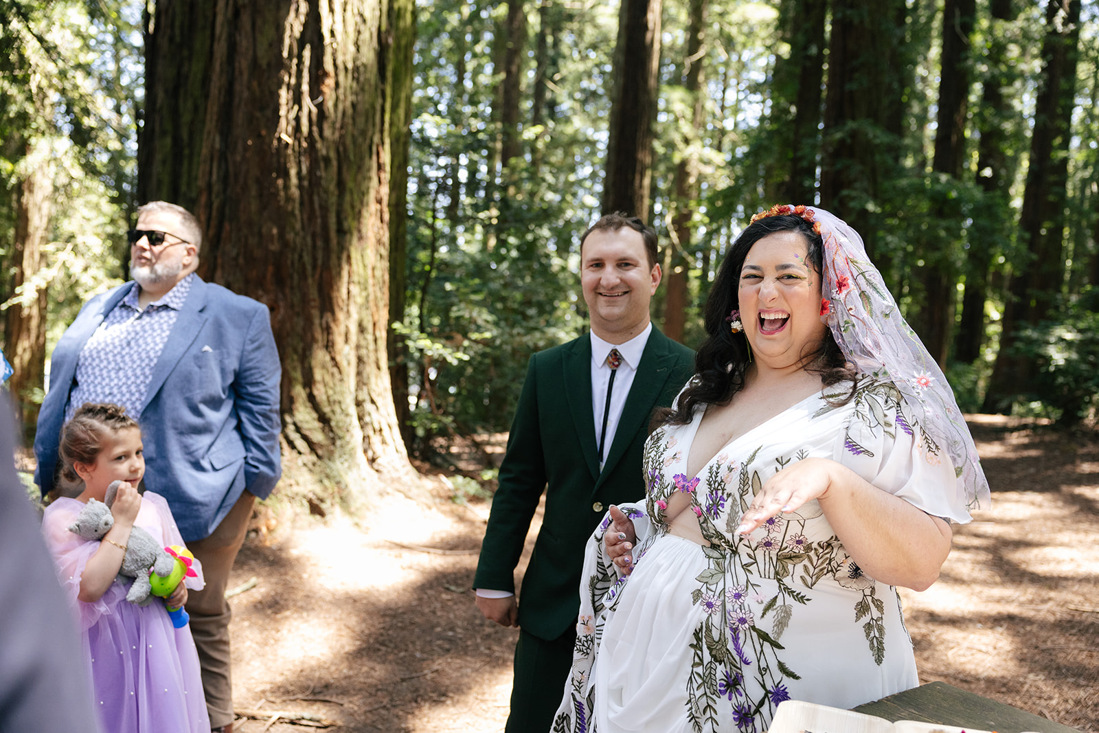 a couple smiling together in the woods of roberts regional park on the day of their wedding