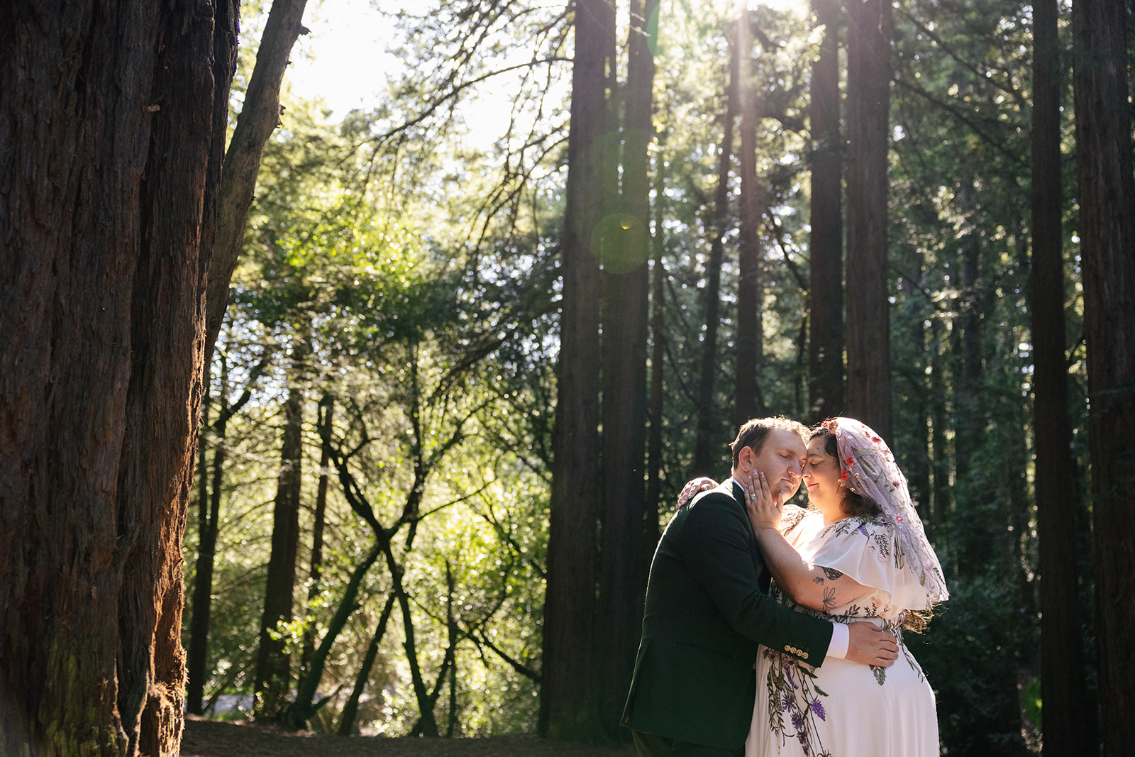 a couple holding one another taking couple wedding portraits in roberts reigonal park