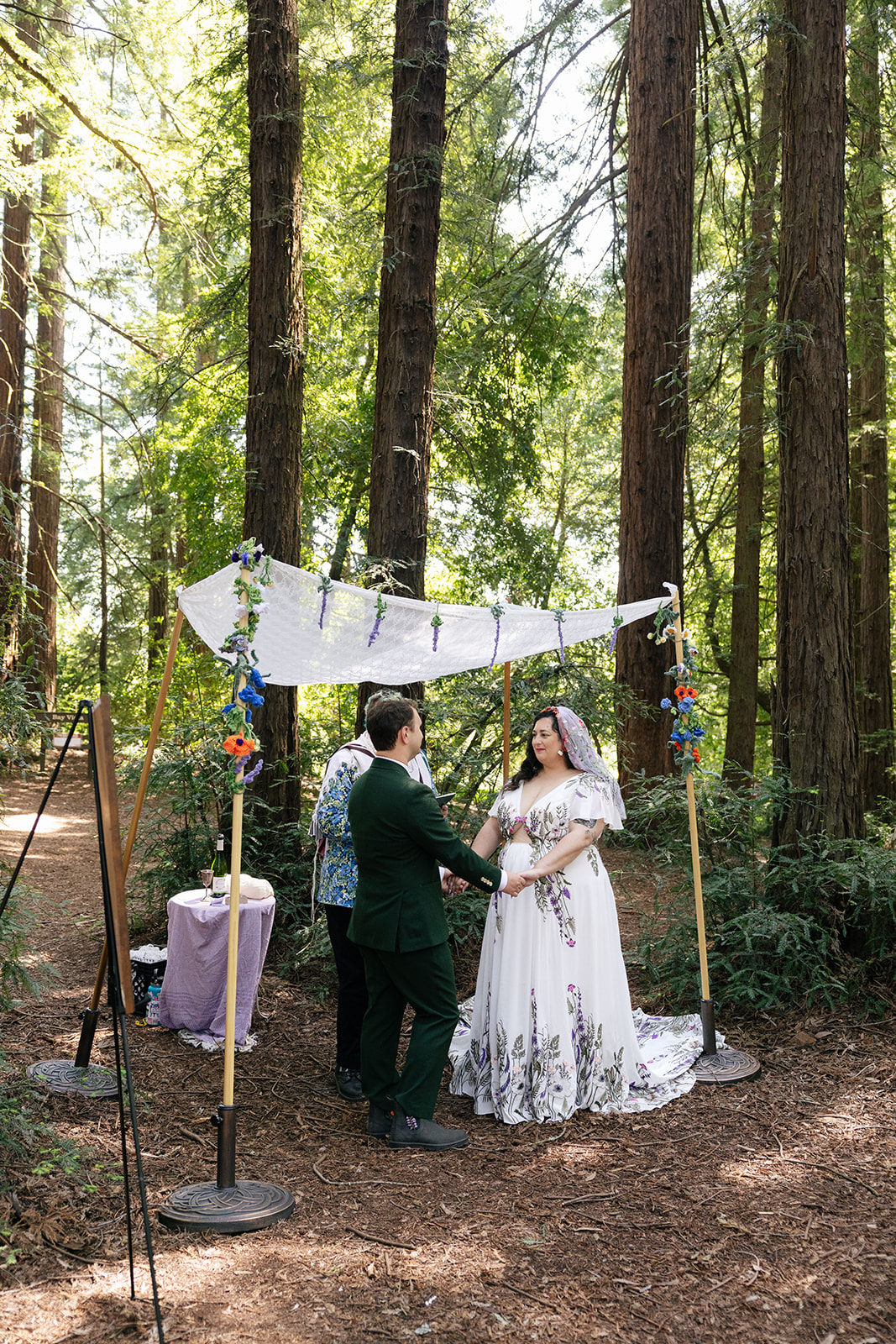 a couple having a jewish wedding ceremony in roberts regional park underneath the redwood trees 