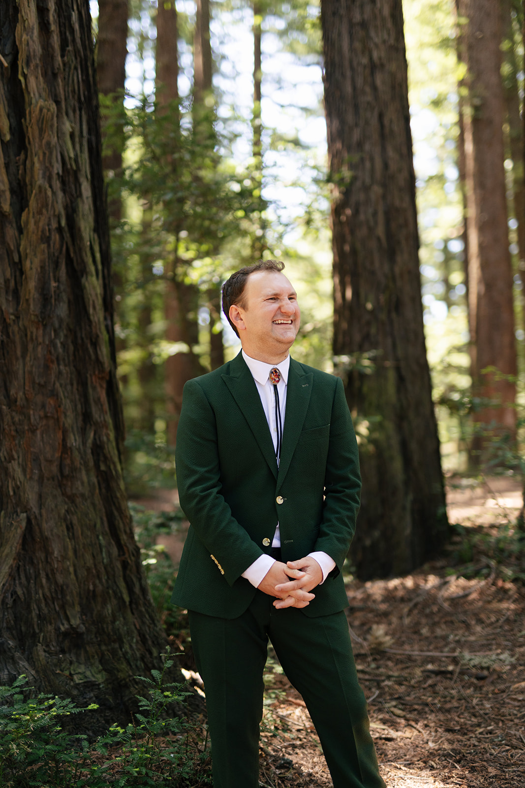 a man laughing taking wedding portraits in roberts regional park 
