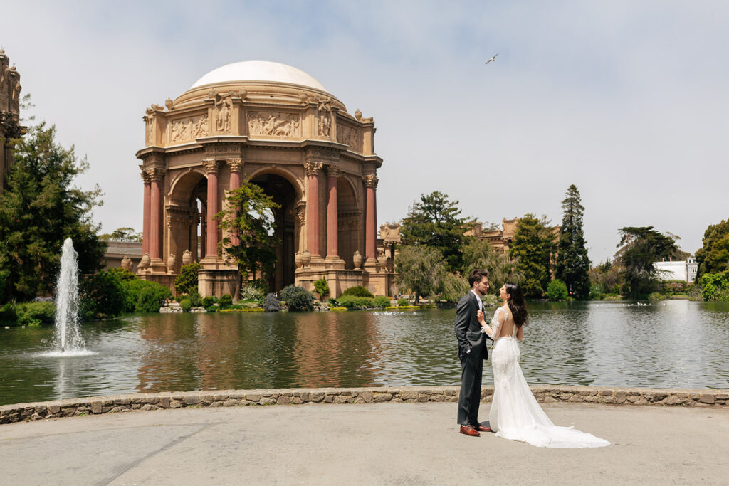 a wedding couple posing in front of the palace of fine arts