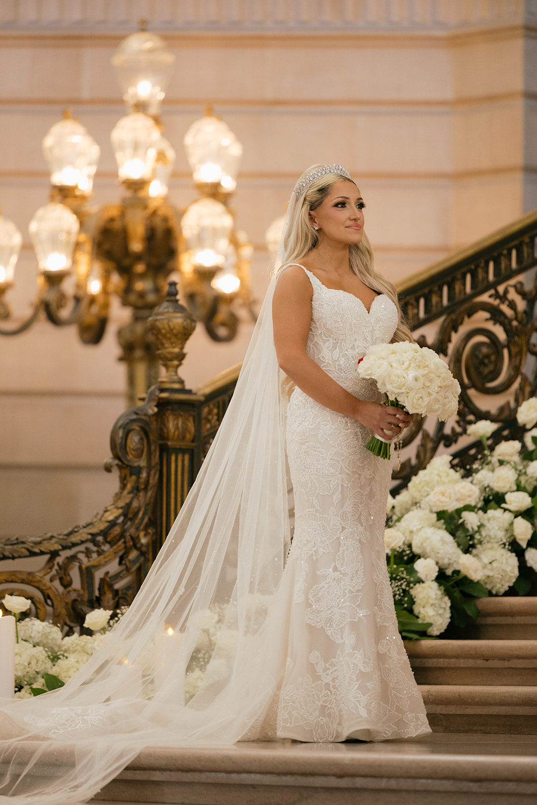 a bride standing on the grand staircase inside of san francisco city hall 