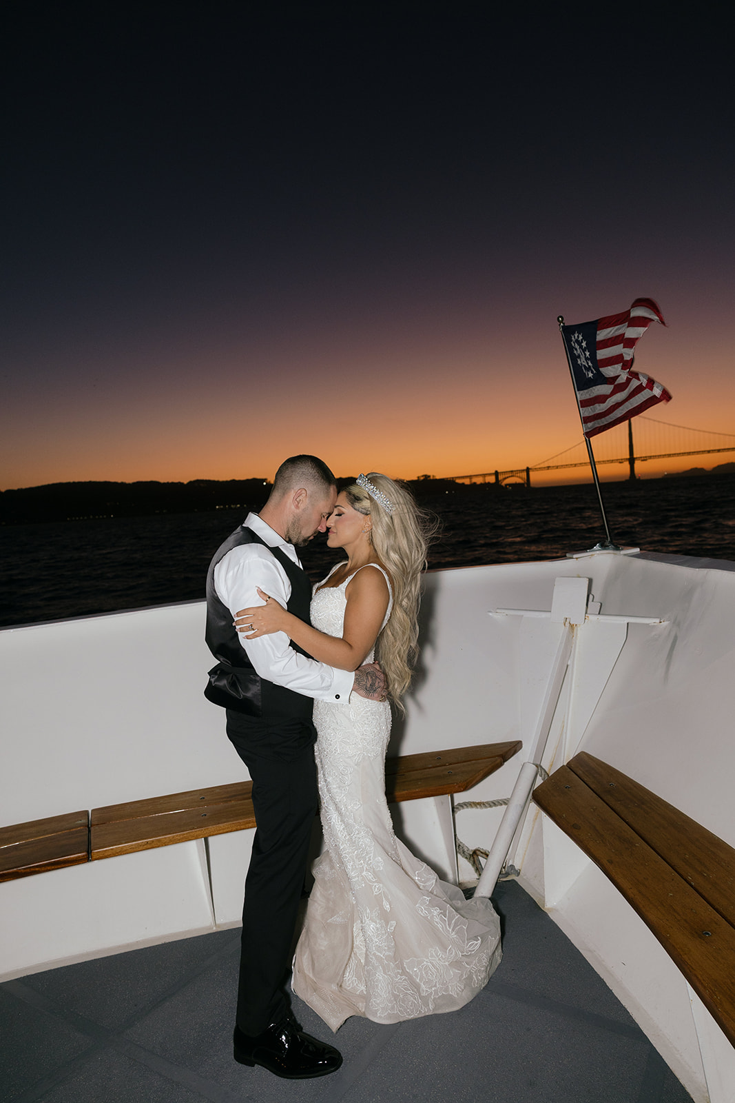a couple taking night portraits during their wedding reception on a yacht on the san francisco bay 