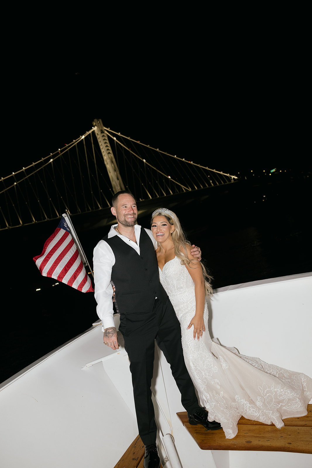 a couple taking night portraits on a yacht during their wedding reception on the san francisco bay 