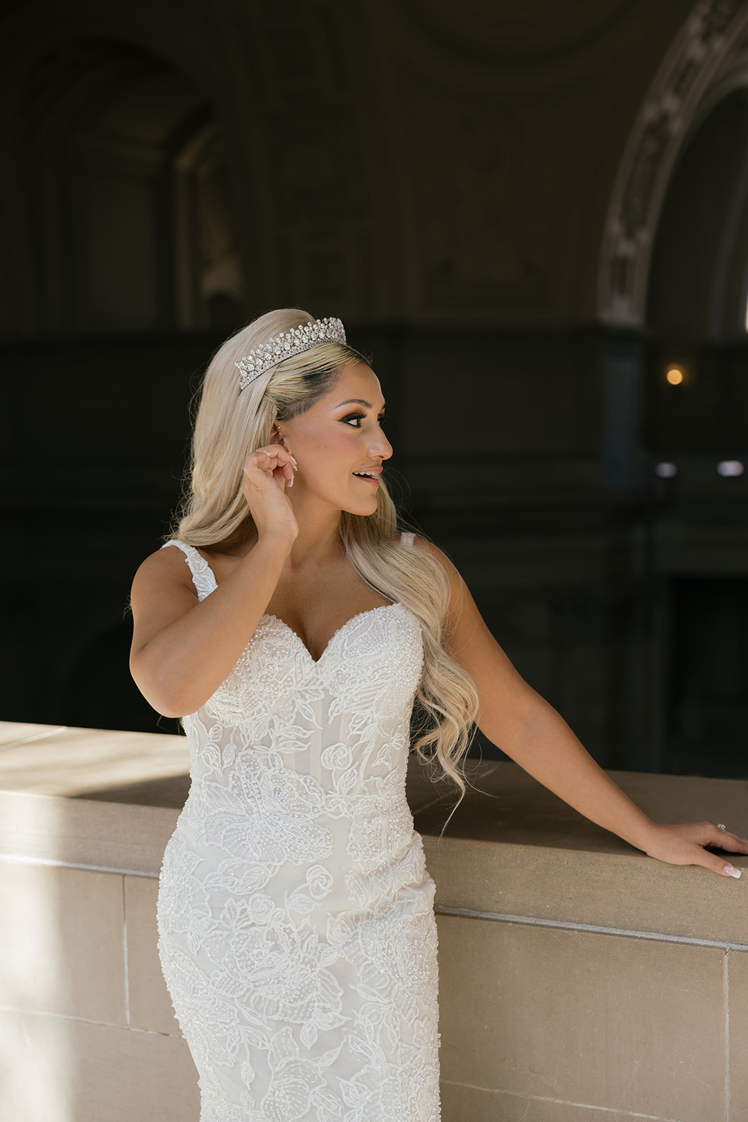 a bride taking a wedding portrait on the mayor's balcony of san francisco city hall 